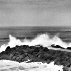 Photographie de vague s'écrasant sur la digue