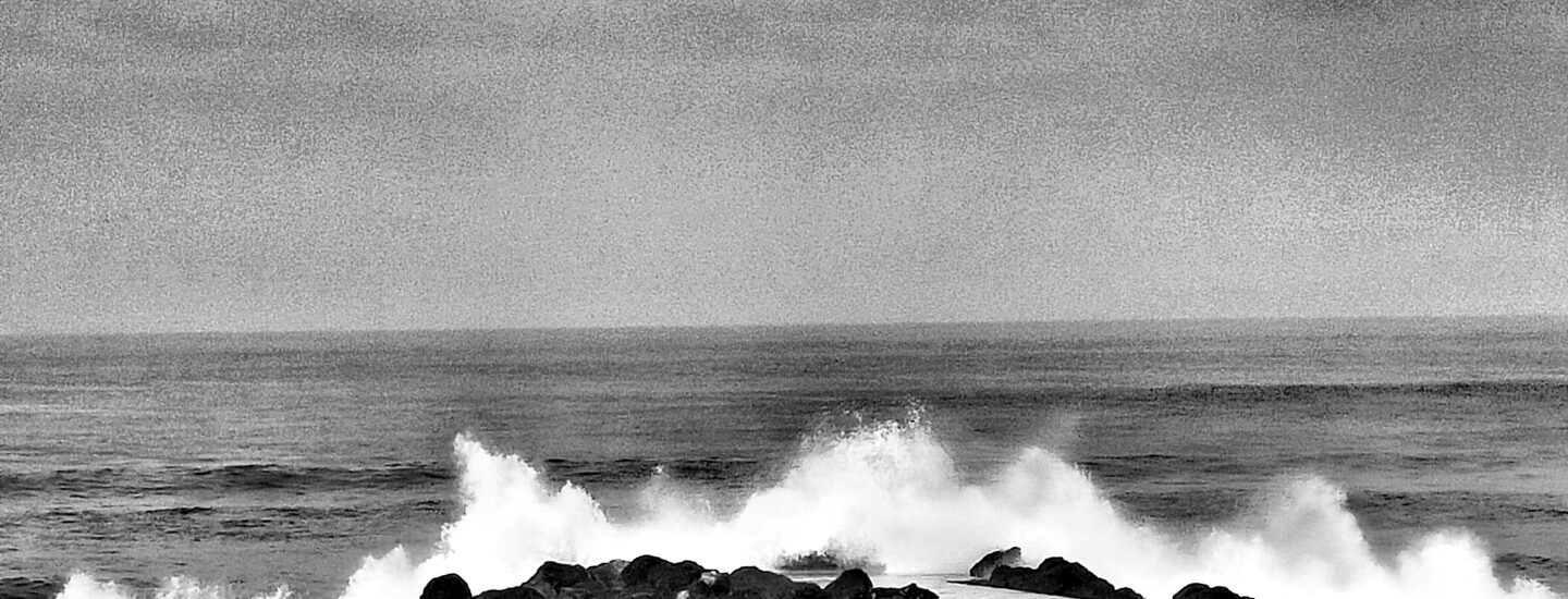 Photographie de vague s'écrasant sur la digue