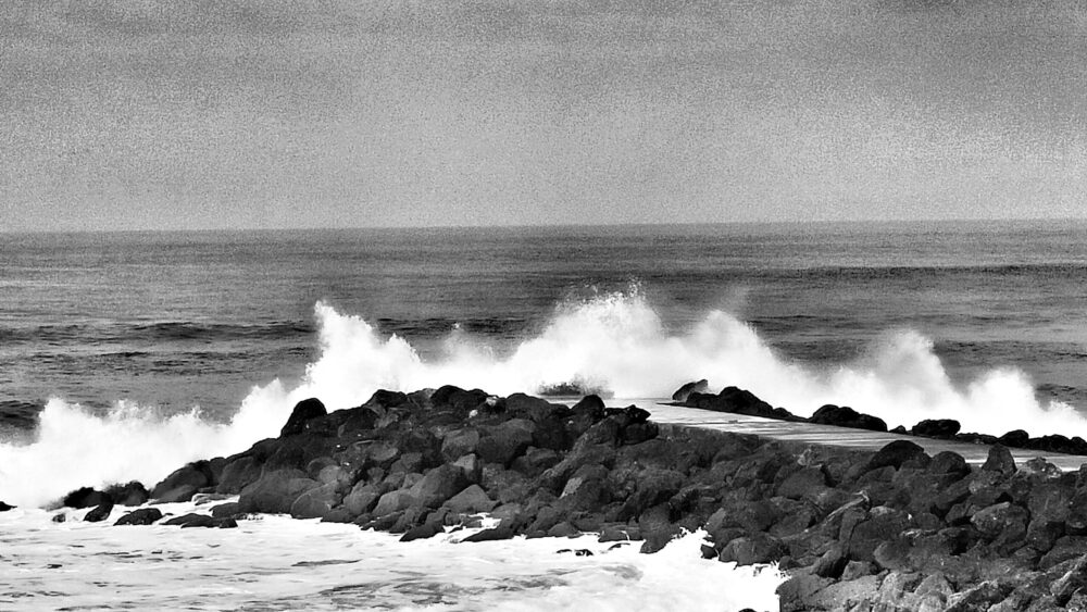 Photographie de vague s'écrasant sur la digue