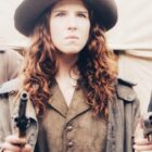 Photogramme du film Calamity Jane. L'héroïne tient un revolver dans chaque main, le regard déterminé.