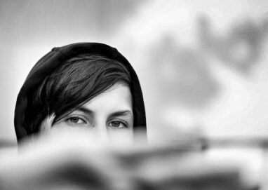 photo d'un regard; le bas du visage est caché par une main