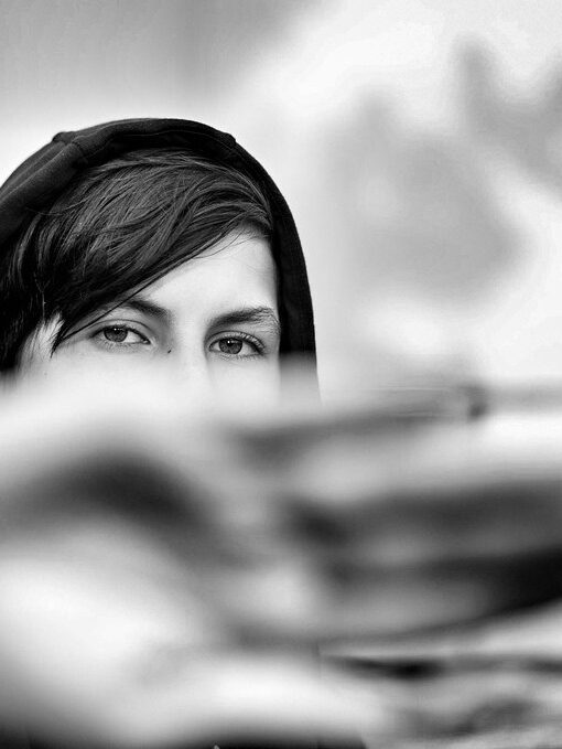 photo d'un regard; le bas du visage est caché par une main