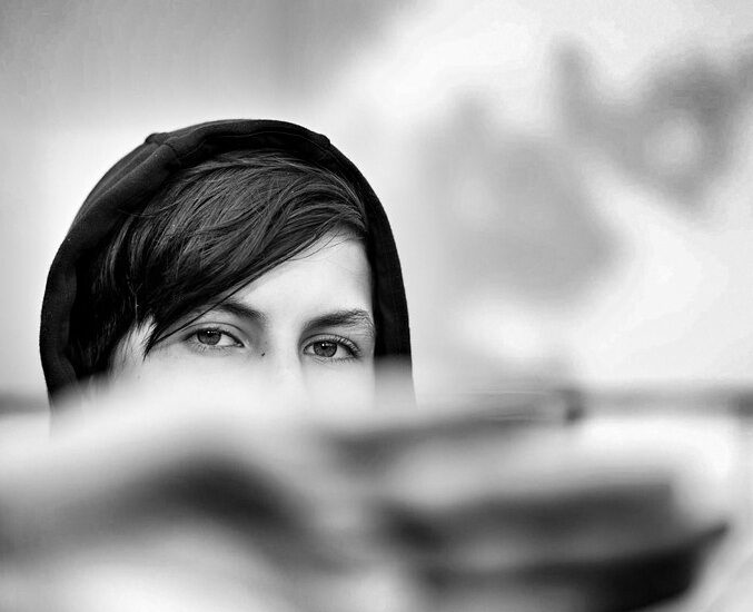 photo d'un regard; le bas du visage est caché par une main