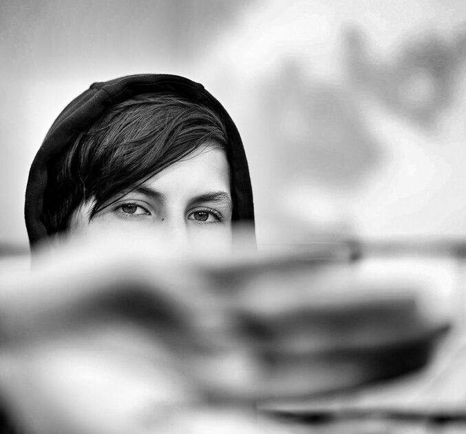 photo d'un regard; le bas du visage est caché par une main