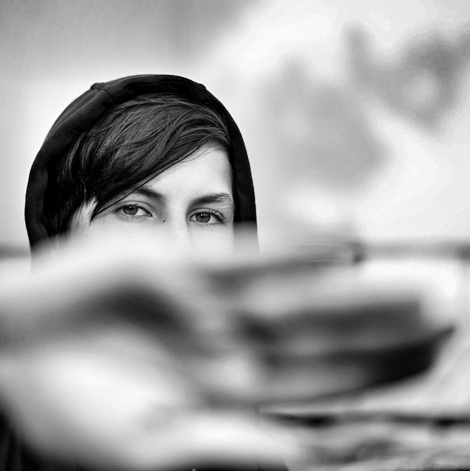 photo d'un regard; le bas du visage est caché par une main