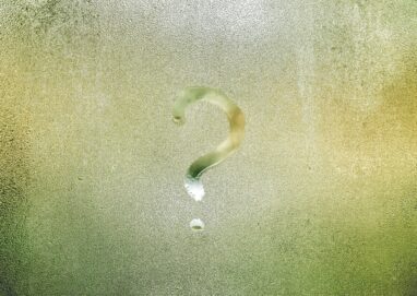 Photo d'un point d'interrogation tracé avec le doigt sur une vitre recouverte de buée