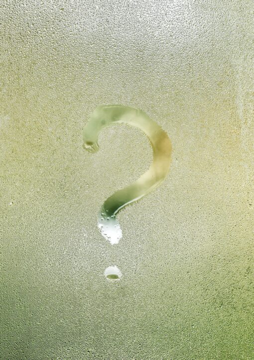 Photo d'un point d'interrogation tracé avec le doigt sur une vitre recouverte de buée