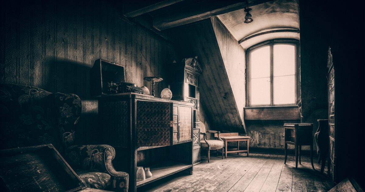 Photo d'une pièce ressemblant à un grenier de maison de maître (parquet, lumière sépia, vieux meubles)