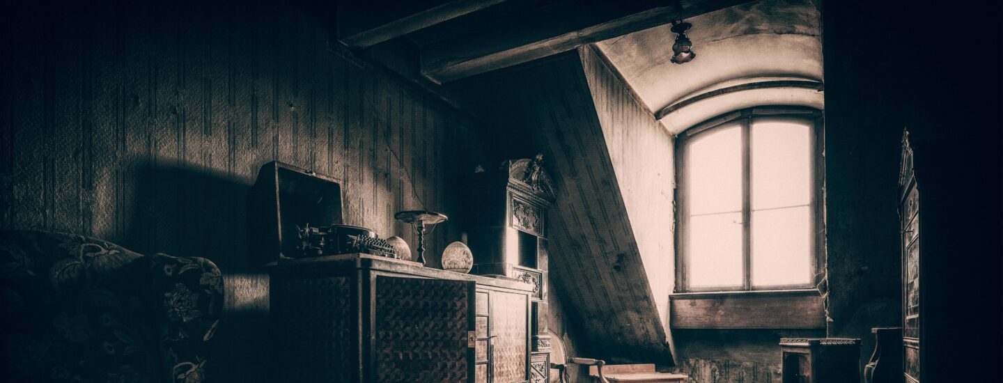 Photo d'une pièce ressemblant à un grenier de maison de maître (parquet, lumière sépia, vieux meubles)