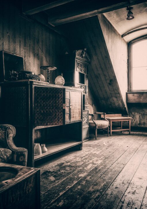 Photo d'une pièce ressemblant à un grenier de maison de maître (parquet, lumière sépia, vieux meubles)
