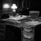 bureau en bois. Photographie Noir et blanc. Lampe ancienne.