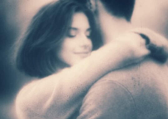 Couple enlacé. Visage serein et souriant de la femme, amoureuse.