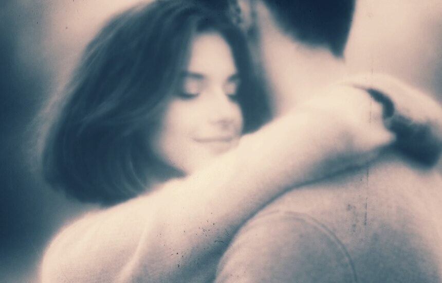 Couple enlacé. Visage serein et souriant de la femme, amoureuse.