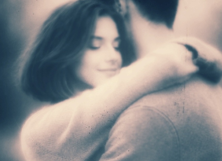 Couple enlacé. Visage serein et souriant de la femme, amoureuse.